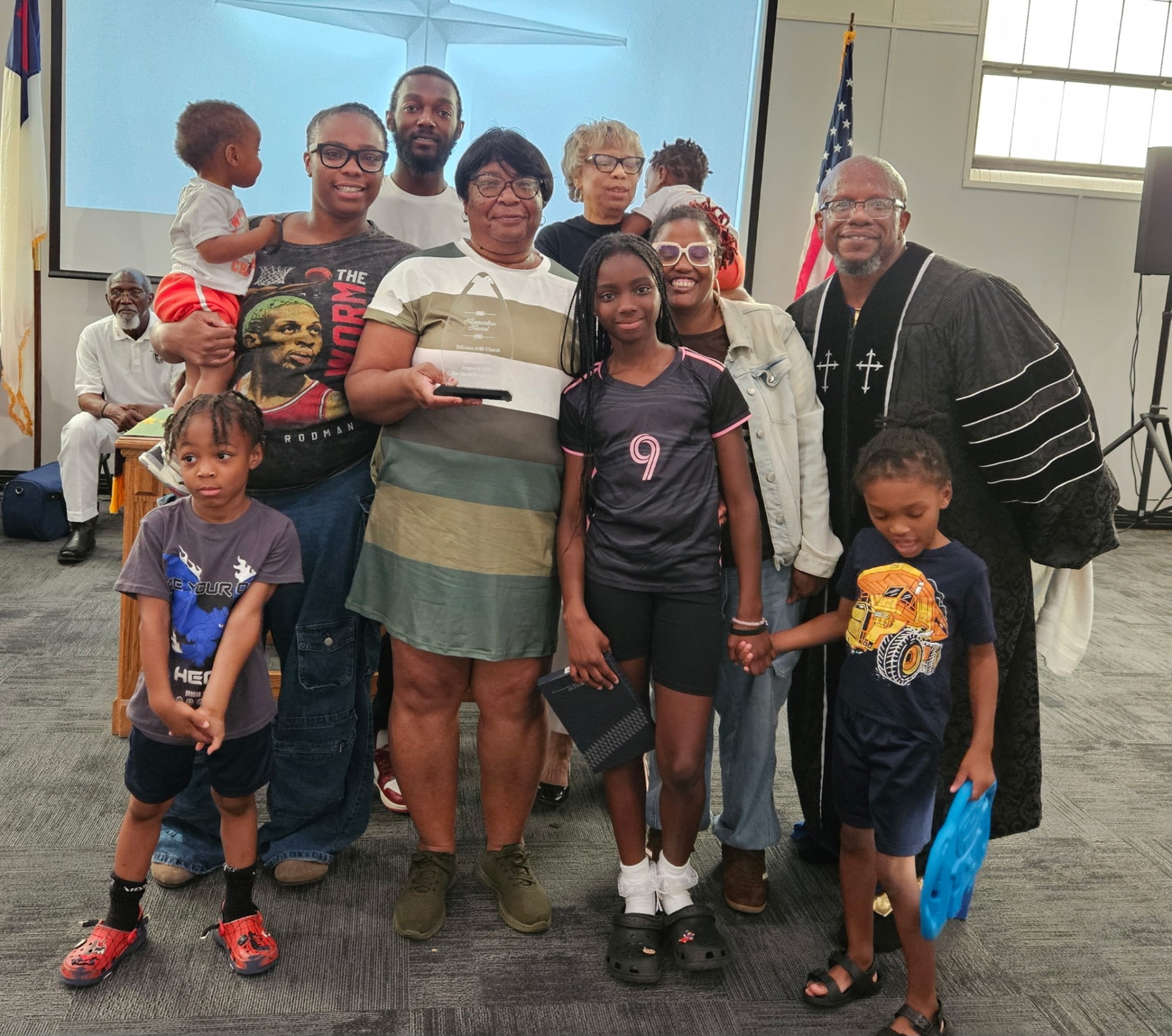 Woman of the Year surrounded by family and Rev. David Parker after the presentation