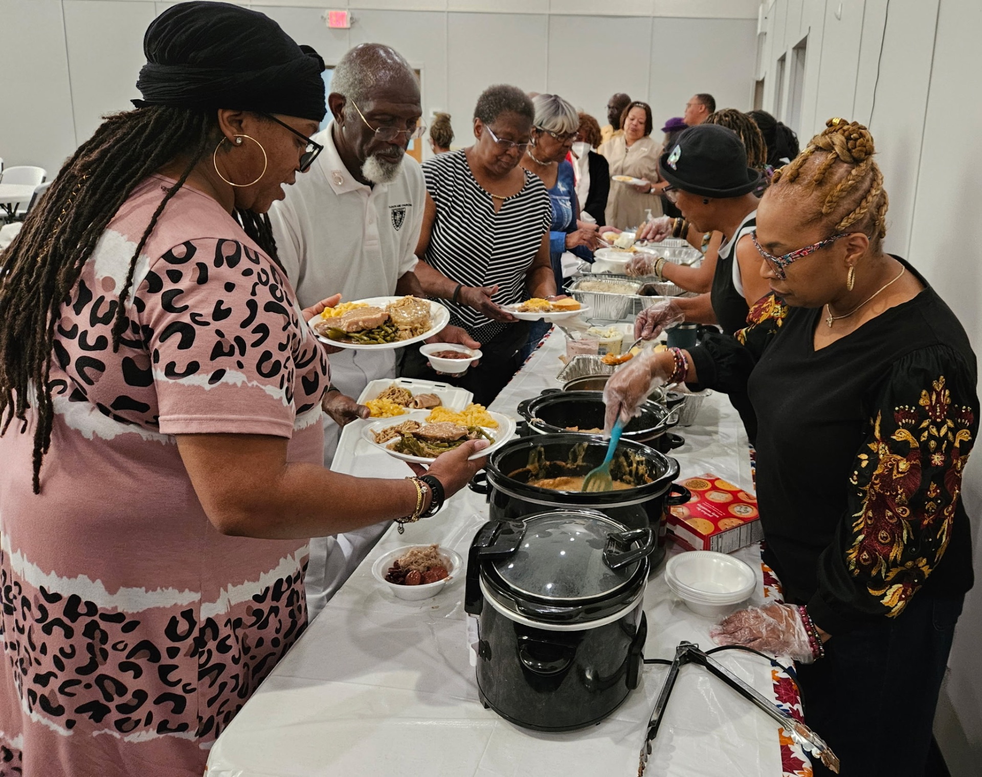 Members serving plates along the fellowship buffet line