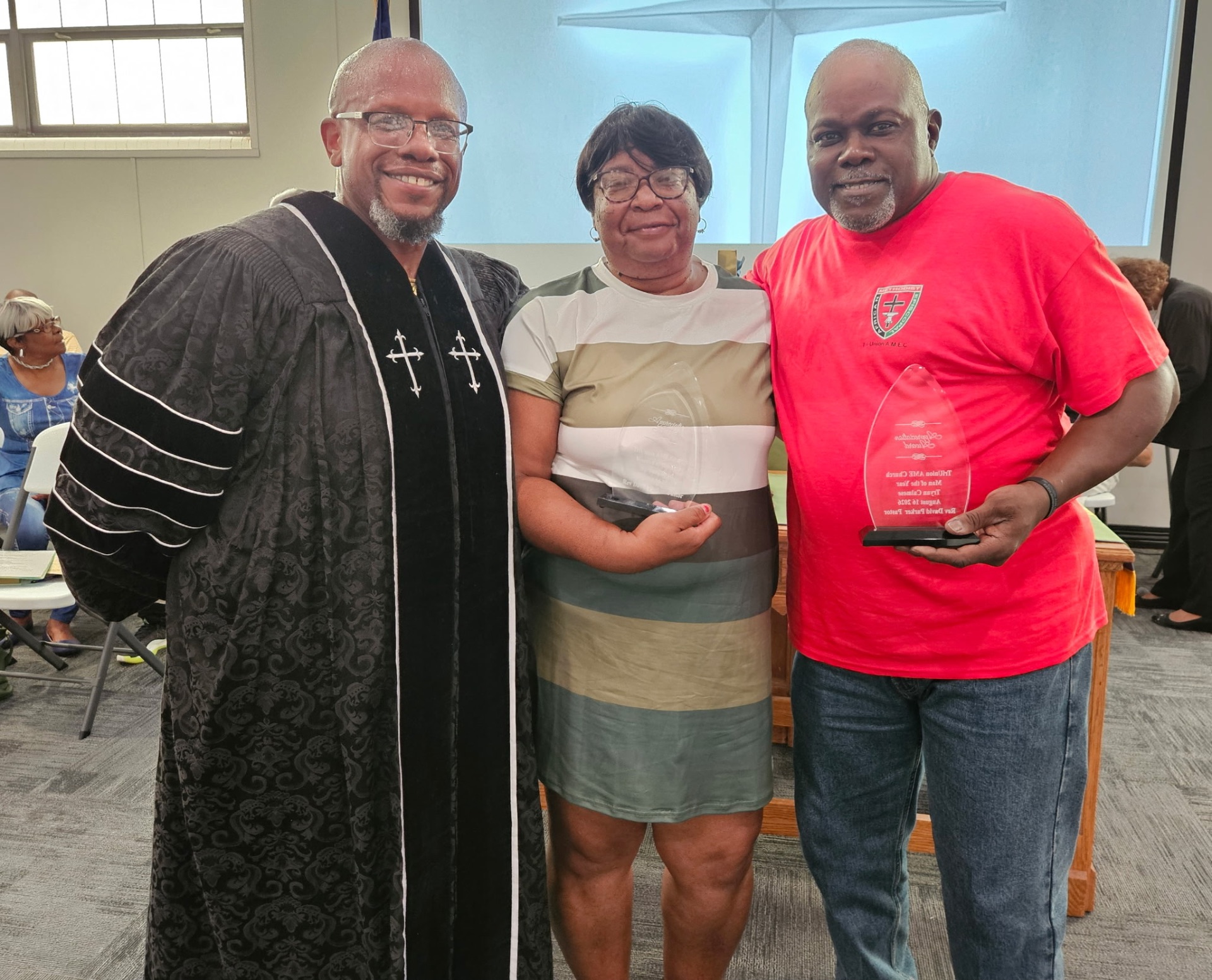 Rev. David Parker with the Woman of the Year and Man of the Year holding their awards