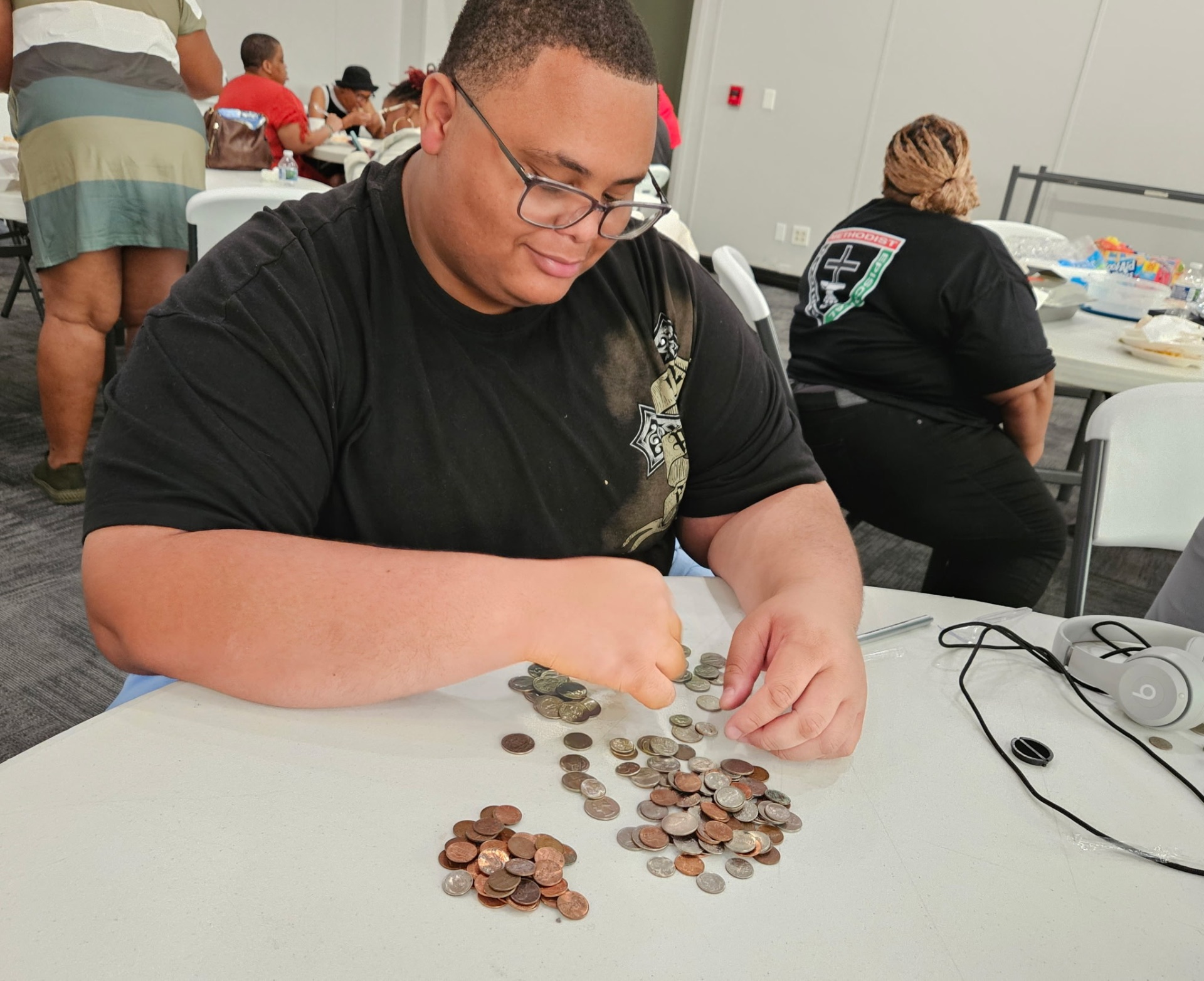 Youth member counting coins for the church fundraiser